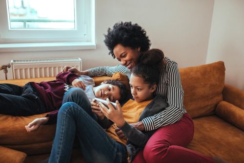 Shot of a mother looking at something on the mobile phone with her children concept for Parenting Tips — Before, During and After the Divorce