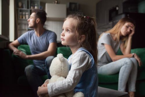 Little girl holding toy dreaming that family conflicts would stop, suffering from mother and father quarrels, bad family relationship, break up Legal concept for Make Divorce Easier on Your Kid: Benefits of Divorce Mediation.