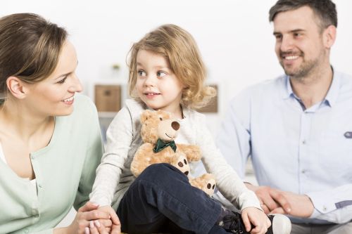 Family with a mother and daughter holding a teddy bear in the father in the background. Concept for Understanding the new custody law in Missouri.