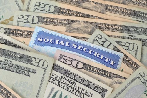 Social security card mixed in with money as a visual concept for family law blog on Divorce and Social Security Benefits.